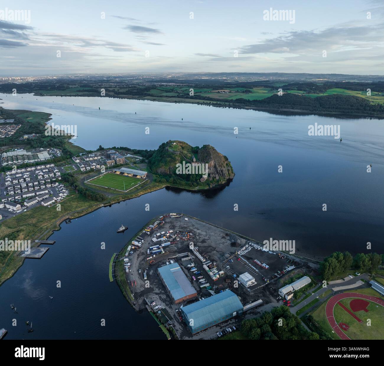 Aus der Vogelperspektive auf den ruhigen Fluss Clyde mit Dumbarton Castle und üppigem Grün in Dumbarton, Schottland. Stockfoto