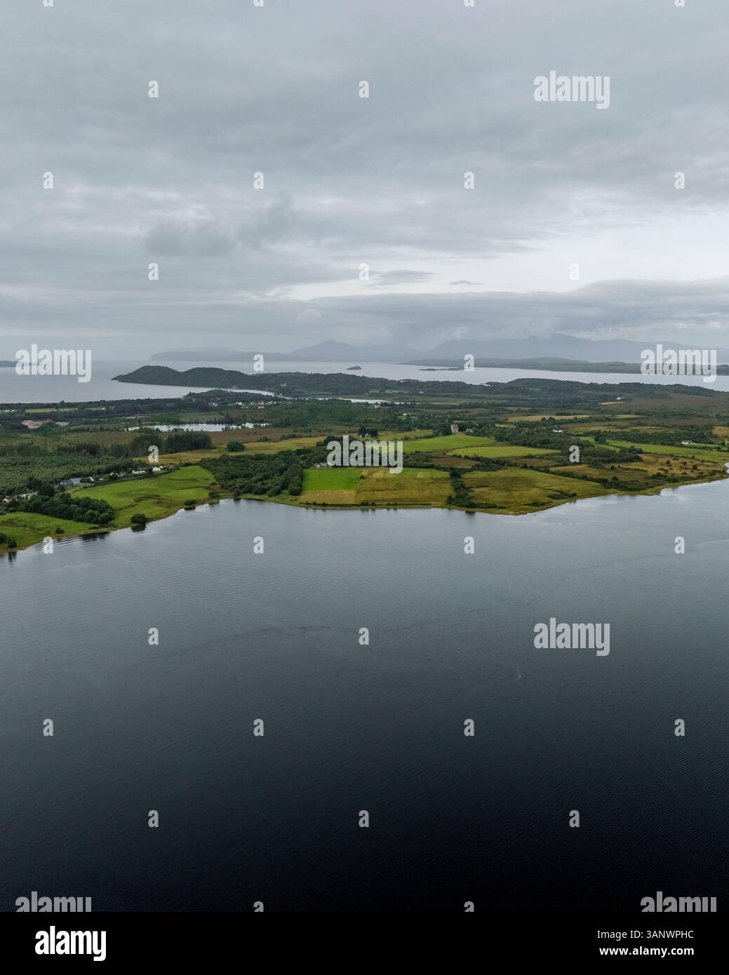 Blick aus der Vogelperspektive auf das ruhige Loch Creran, umgeben von üppigem Grün und Inseln unter einem bewölkten Himmel, Oban, Schottland. Stockfoto