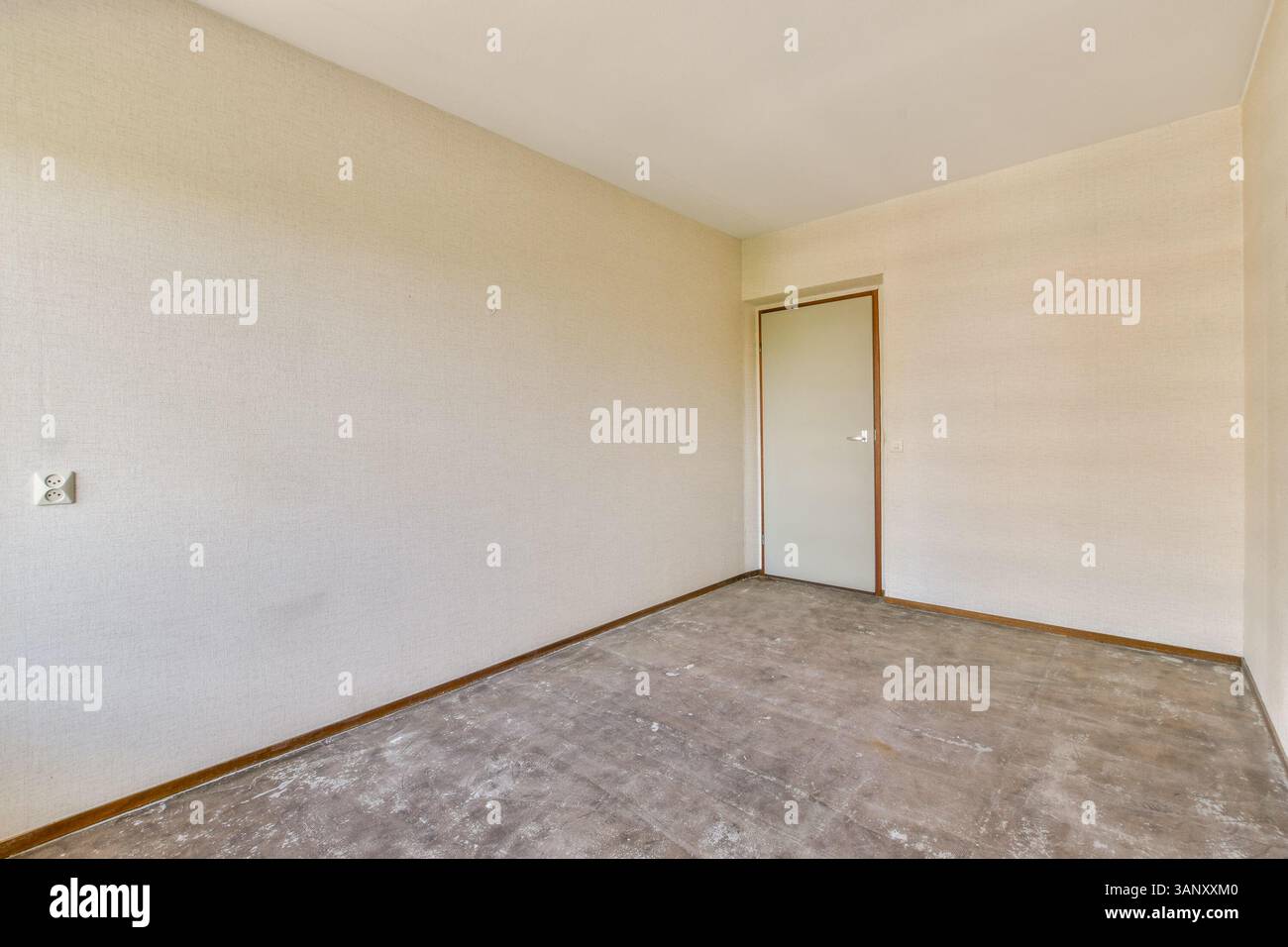 Ein geräumiger, leerer Raum mit neutralen Wänden und einer einzigen Tür bietet ein klares, minimalistisches Design, das perfekt für verschiedene Innenstile geeignet ist. Stockfoto