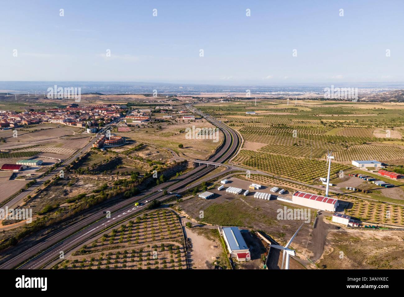 Aus der Vogelperspektive auf die Autobahn, die einen Windpark mit vielen Windturbinen überquert, La Muela, Saragoza, Spanien. Stockfoto