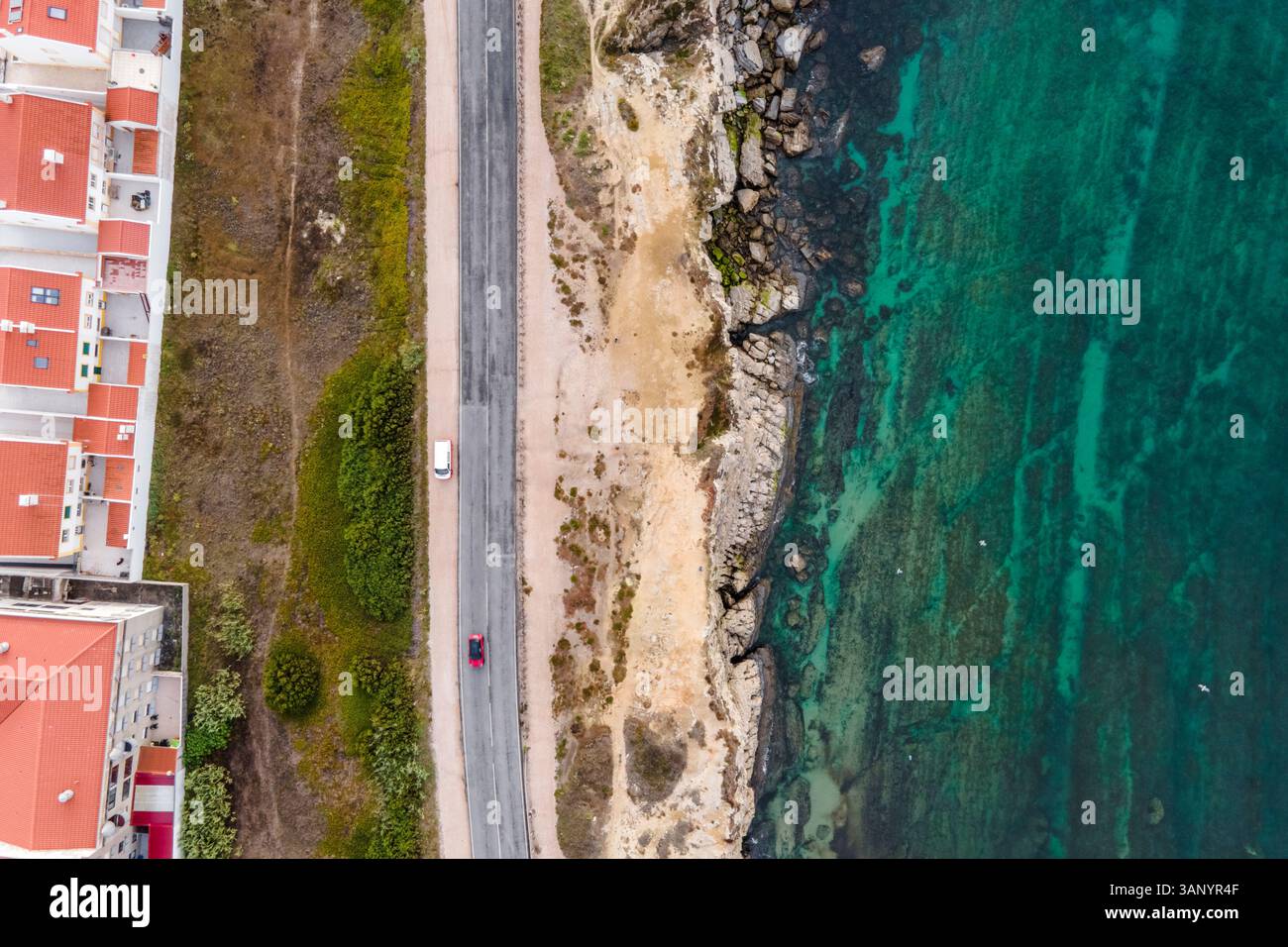 Luftaufnahme von Fahrzeugen auf der Straße entlang der Klippen, Peniche, Portugal. Stockfoto