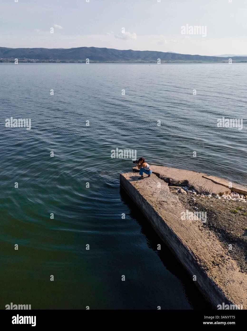 Luftaufnahme einer Frau, die Fotos entlang der Küste des Volvi-Sees in Mirki Volvi, Zentralmakedonien, Griechenland macht. Stockfoto