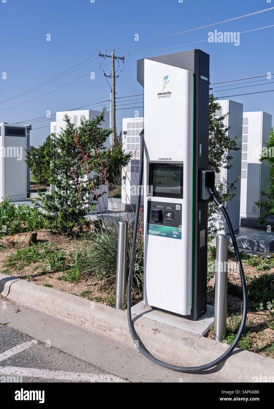 Austin, TX - 11. April 2025: Elektrifizieren Sie die EV-Ladestation in Amerika bei Georgetown, Texas, mit Stromversorgungsgeräten dahinter Stockfoto