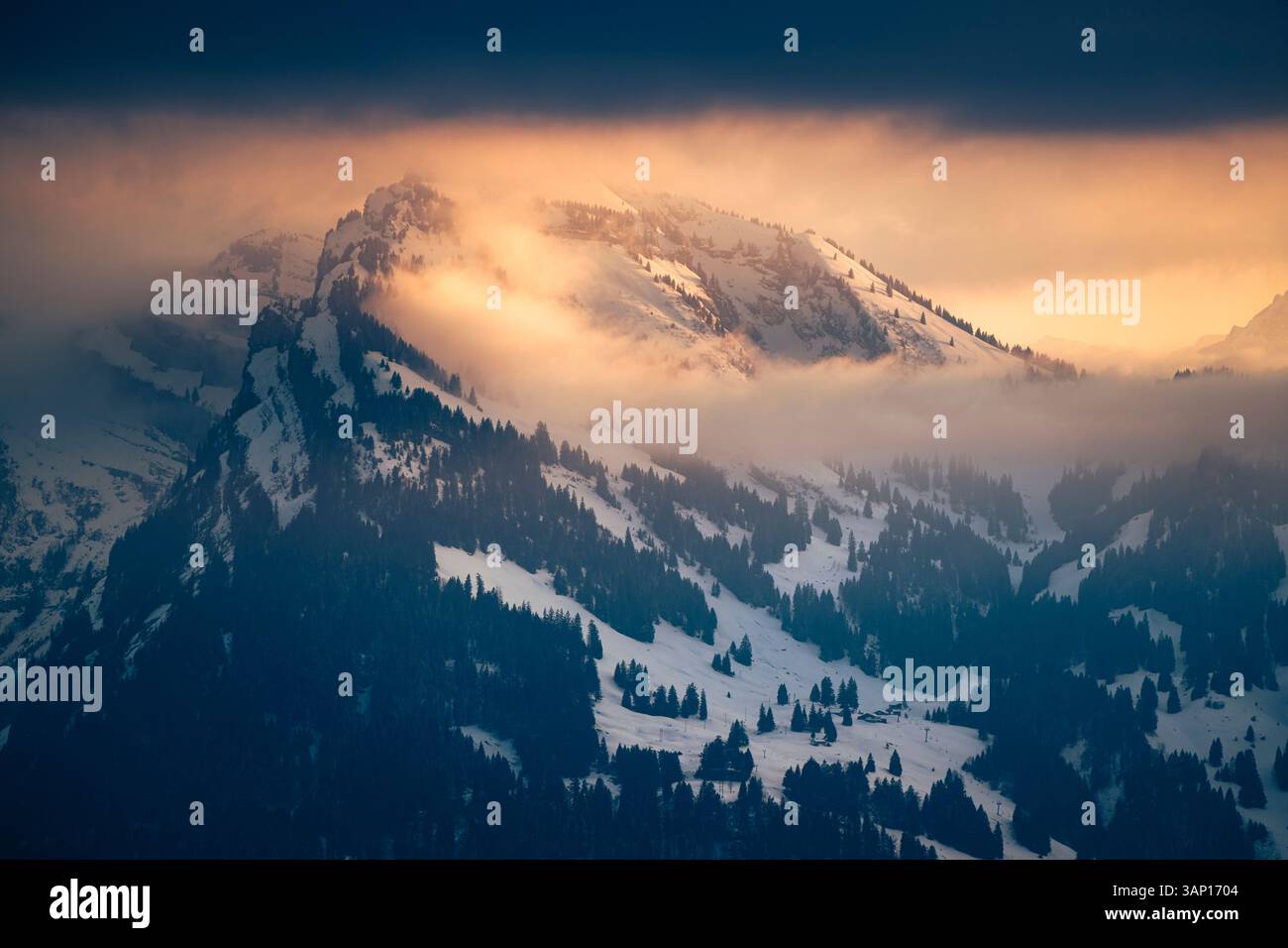 Der Sonnenuntergang beleuchtet die Wolken um die Gipfel der Glarner Alpen am Walensee Stockfoto