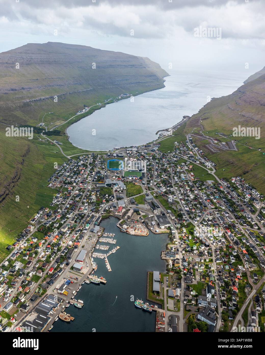 Blick aus der Vogelperspektive auf den malerischen Hafen von Klaksvik, umgeben von wunderschönen Bergen und ruhigem Wasser, Nordoyar, Färöer Inseln. Stockfoto