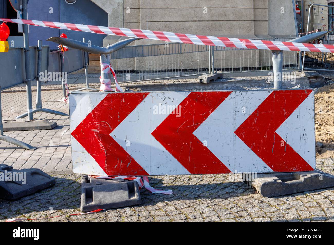 Schild für Straßenarbeiten. Reparaturarbeiten und Umlenkpfeil auf den Straßenpflastersteinen. Hochwertige Fotos Stockfoto