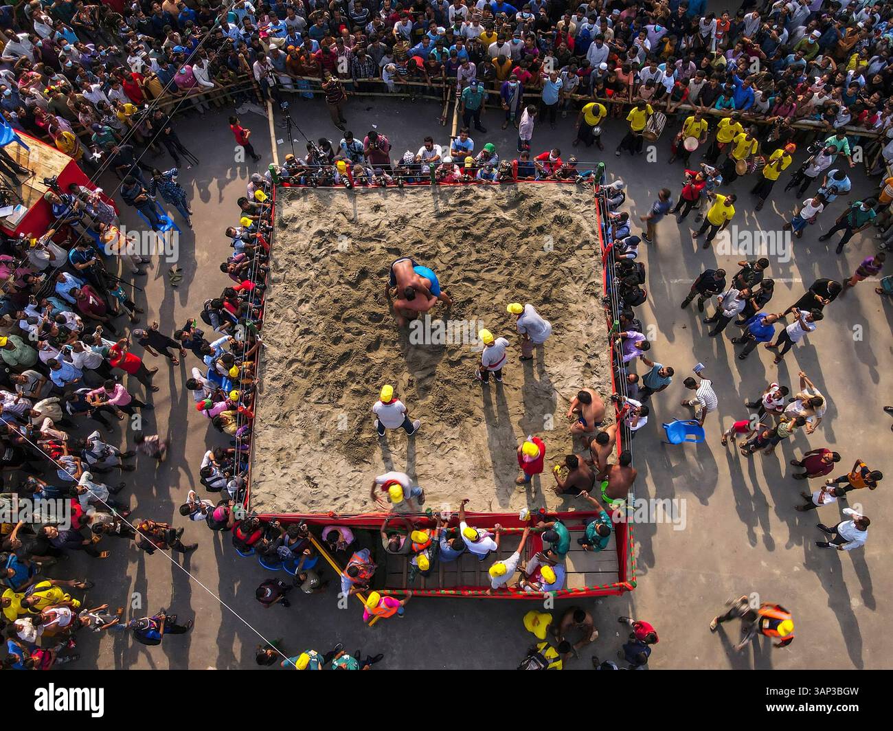 Blick aus der Vogelperspektive auf traditionelle Ringkämpfe mit lebhafter Menschenmenge und farbenfroher Arena, Chittagong, Bangladesch. Stockfoto