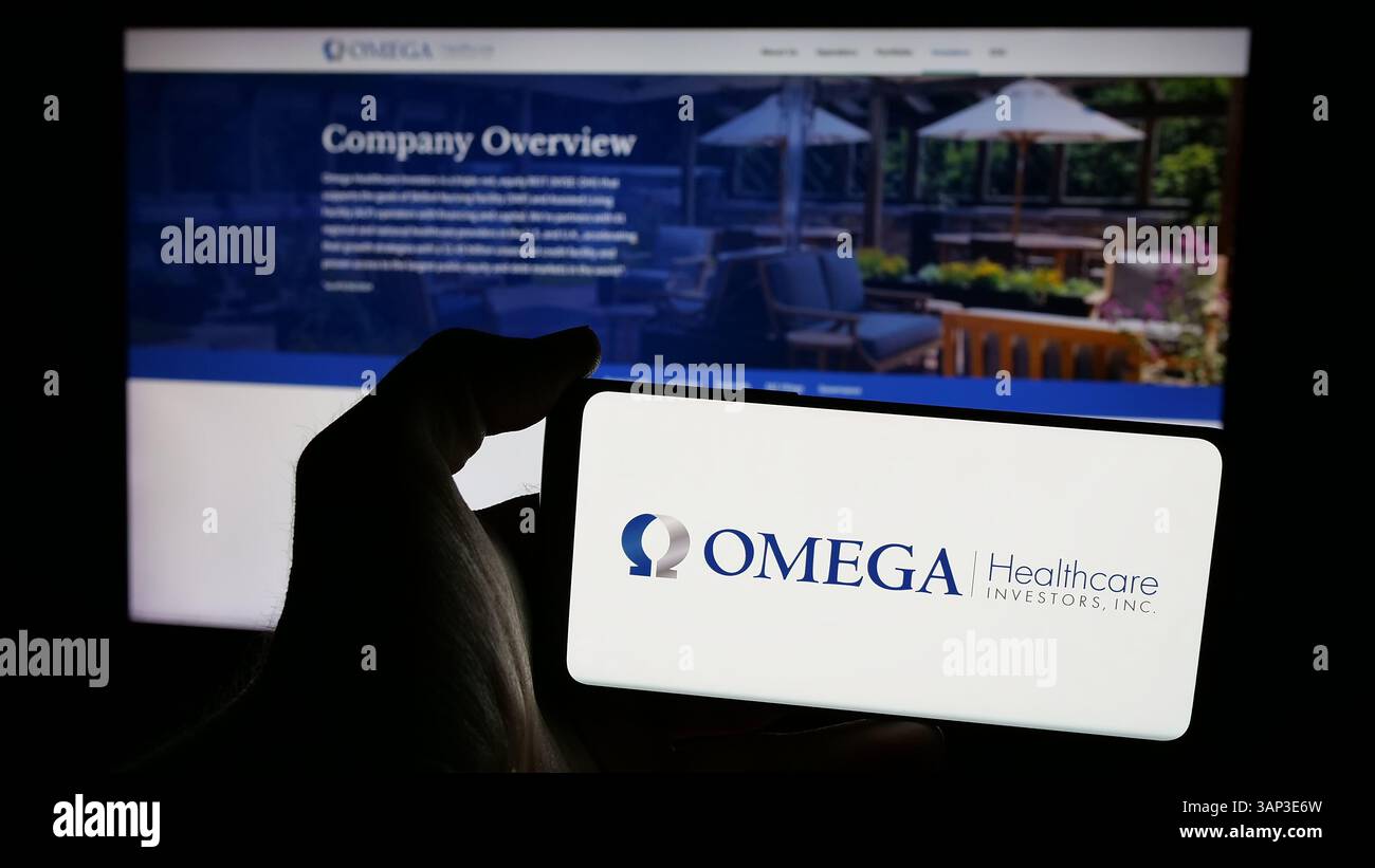 Stuttgart, Deutschland - 12.09.2024: Person, die ein Mobiltelefon mit dem Logo des amerikanischen Unternehmens Omega Healthcare Investors Inc. Auf dem Bildschirm hält Stockfoto