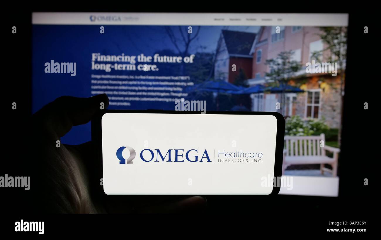 Stuttgart, Deutschland - 12.09.2024: Person, die ein Mobiltelefon mit dem Logo des US-amerikanischen Unternehmens Omega Healthcare Investors Inc. Auf dem Bildschirm hält Stockfoto