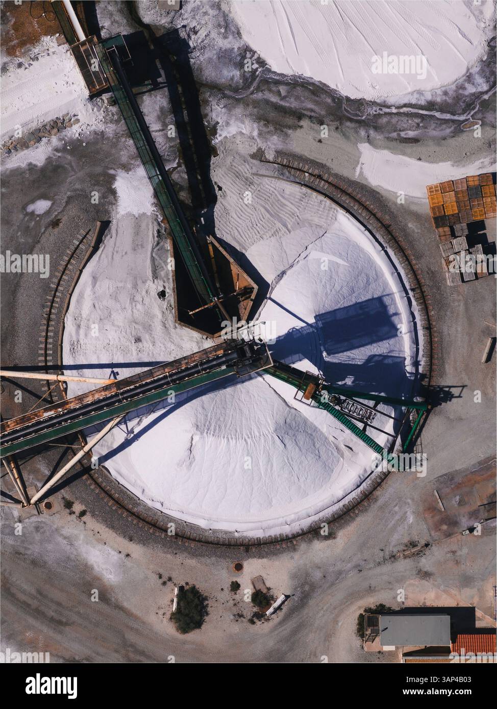 Luftaufnahme der Salzproduktionsanlage mit Maschinen und großen Salzpfählen in Aigues-Mortes, Frankreich. Stockfoto