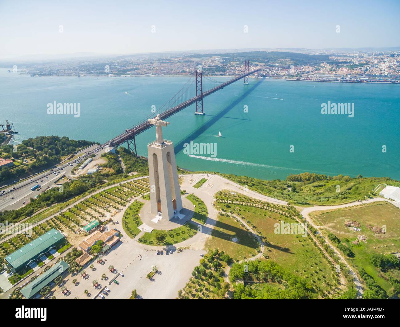 Blick aus der Vogelperspektive auf das Heiligtum Christi des Königs mit Blick auf Lissabon und die Brücke 25 de Abril, die Lissabon und Almada verbindet. Stockfoto