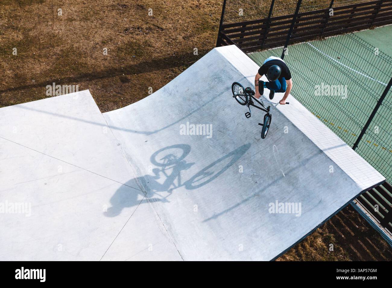 Luftaufnahme eines BMX-Radfahrers, der auf der Rampe im Skatepark Panevezys, Litauen, springt und trickt. Stockfoto