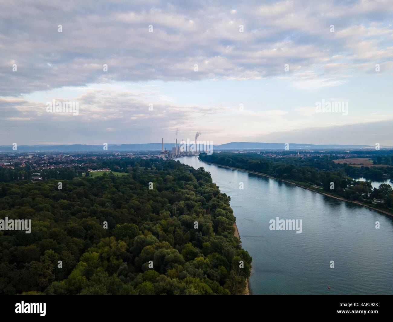 Aus der Vogelperspektive auf den ruhigen Neckar, umgeben von üppigen grünen Wäldern und Stadtlandschaft unter bewölktem Himmel, Mannheim, Baden Wuttermberg, Deutschland. Stockfoto