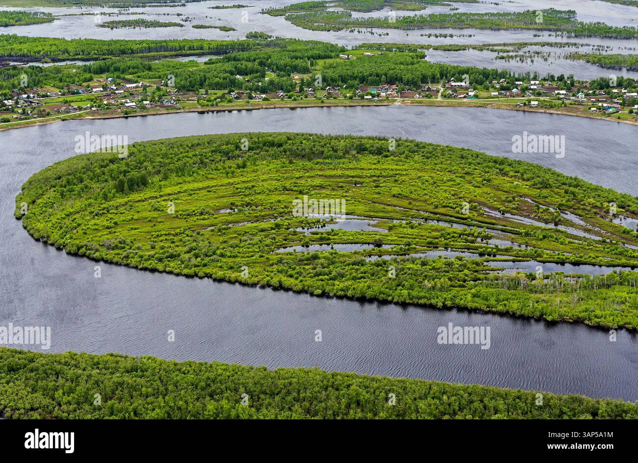 Aus der Vogelperspektive auf den sich windenden Amgun-Fluss mit üppiger Vegetation und einer ruhigen Insel, der Region Khabarowsk, Russland. Stockfoto