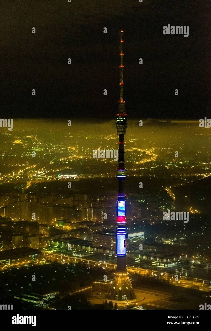 Aus der Vogelperspektive des beleuchteten ostankino-Turms inmitten einer lebhaften Stadtlandschaft bei Nacht, Moskau, Russland. Stockfoto
