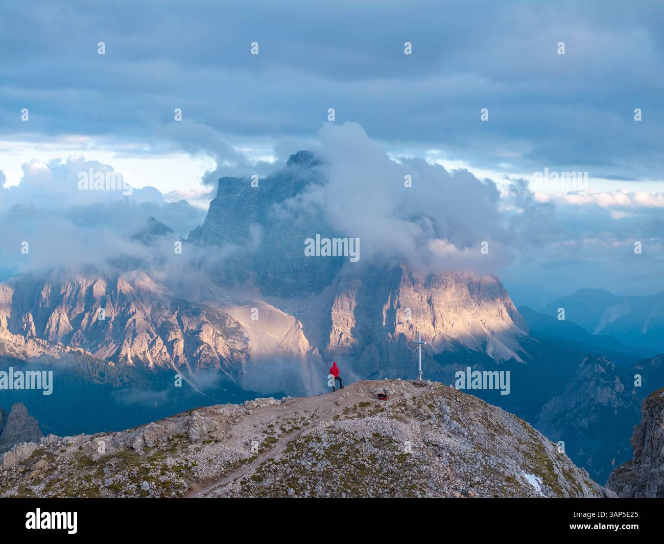 Aerial view of majestic mountains under a cloudy sky with a hiker in the serene landscape, Selva di Cadore, Italy. Stockfoto