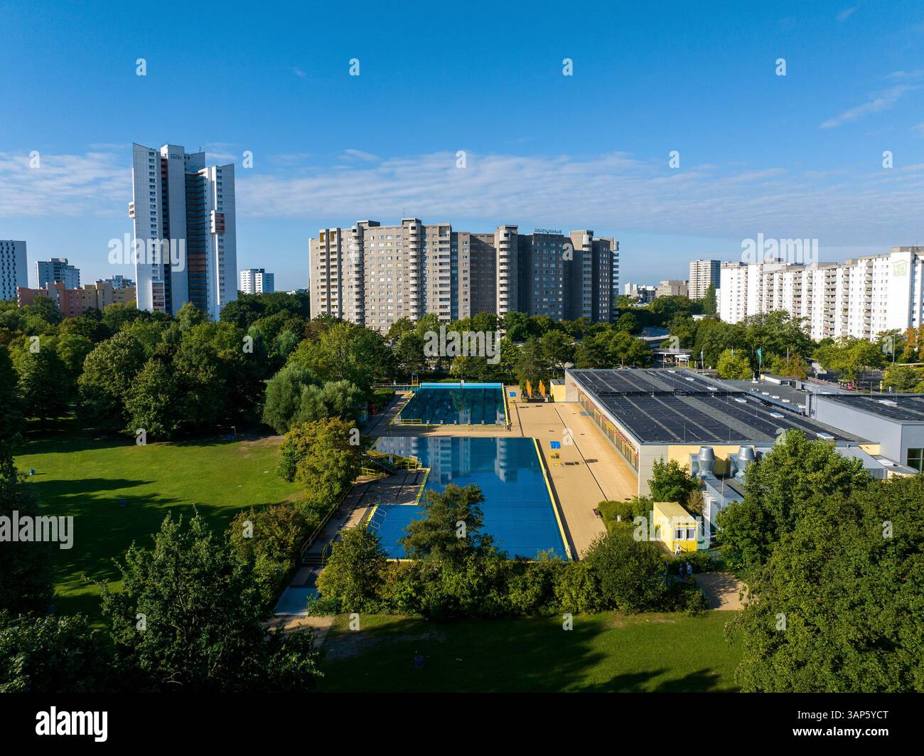 Blick aus der Vogelperspektive auf lebendige öffentliche Pools, umgeben von Hochhäusern und üppigem Grün, Gropiusstadt, Berlin, Deutschland. Stockfoto