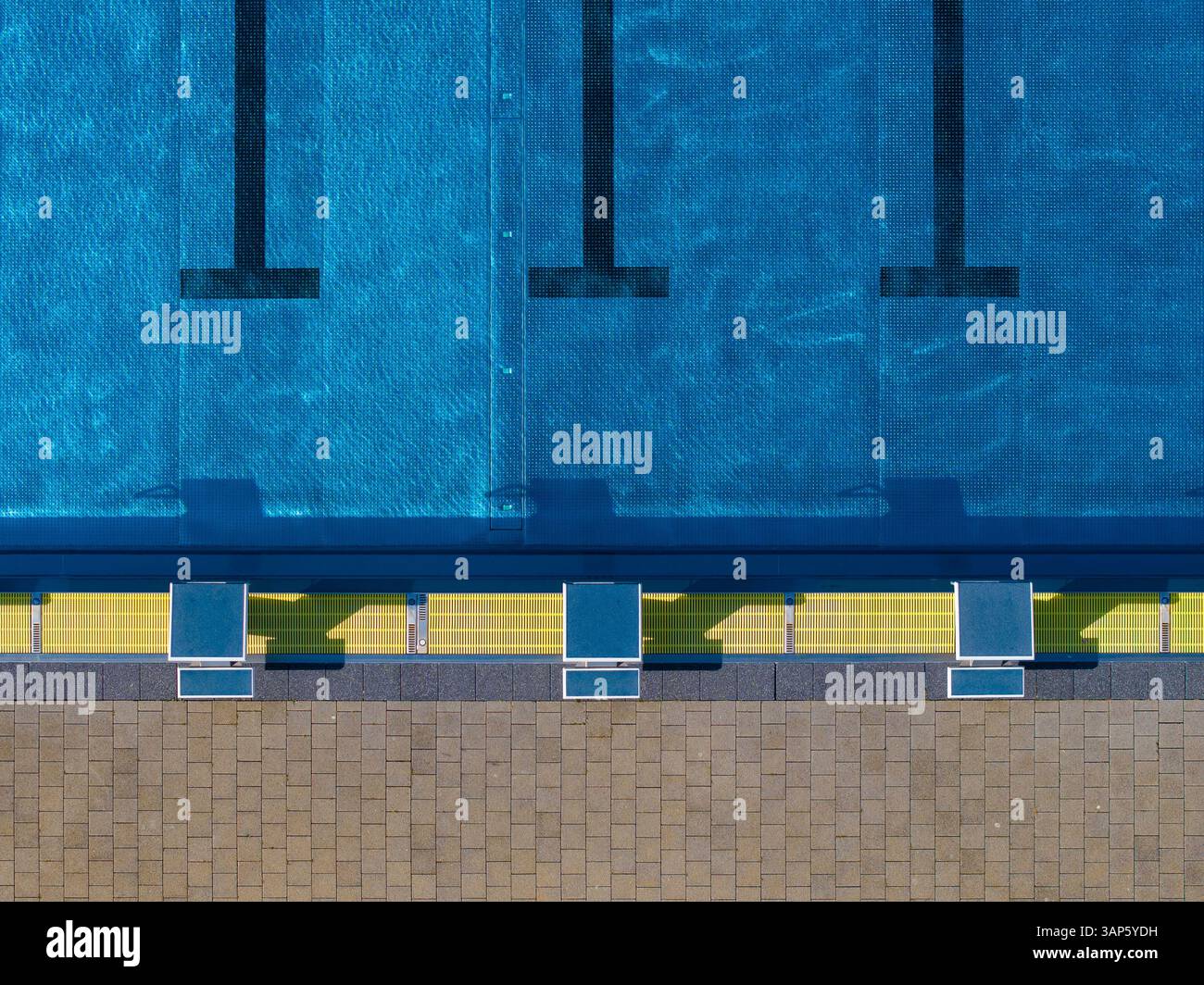 Blick aus der Vogelperspektive auf öffentliche Schwimmbäder mit blauem Wasser und Sprungbrettern, Gropiusstadt, Berlin, Deutschland. Stockfoto