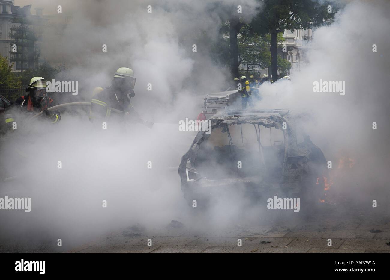 Die Feuerwehr löscht nach den Unruhen auf dem G20-Gipfel 2017 brennende Autos auf der Elbchaussee in Hamburg Stockfoto