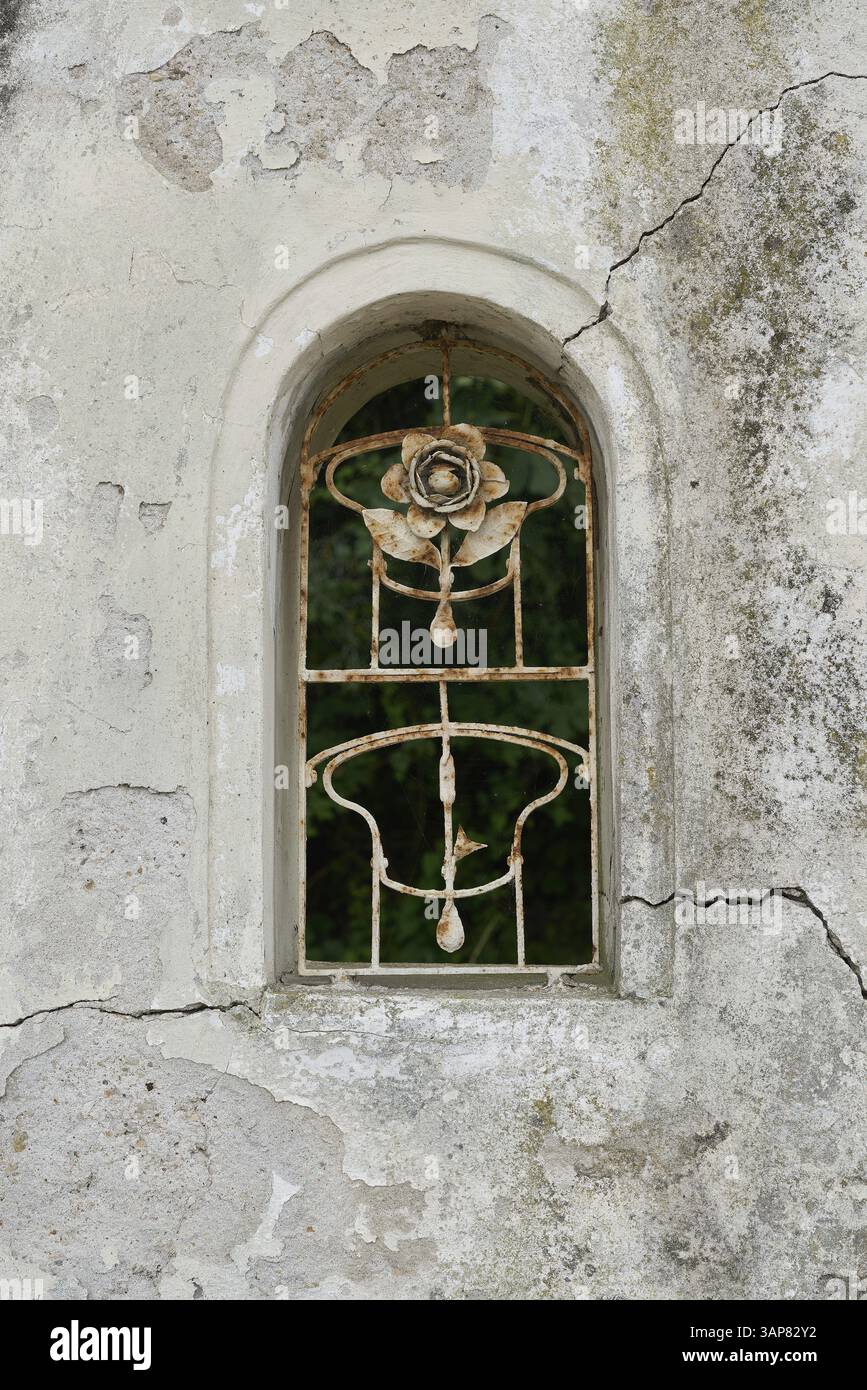Fenster öffnen mit geschmiedetem Grill in einer Mauer zu einem Anwesen in Malcesine in Italien Stockfoto