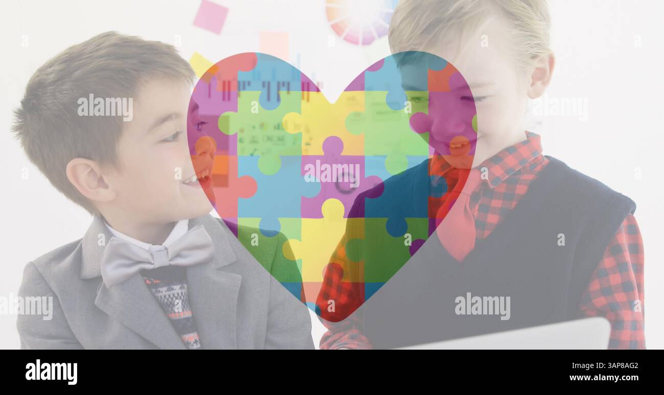 Bild des Autismus-Awareness-Monats bunte Puzzleteile, die das Herz über Schuljungen bilden Stockfoto
