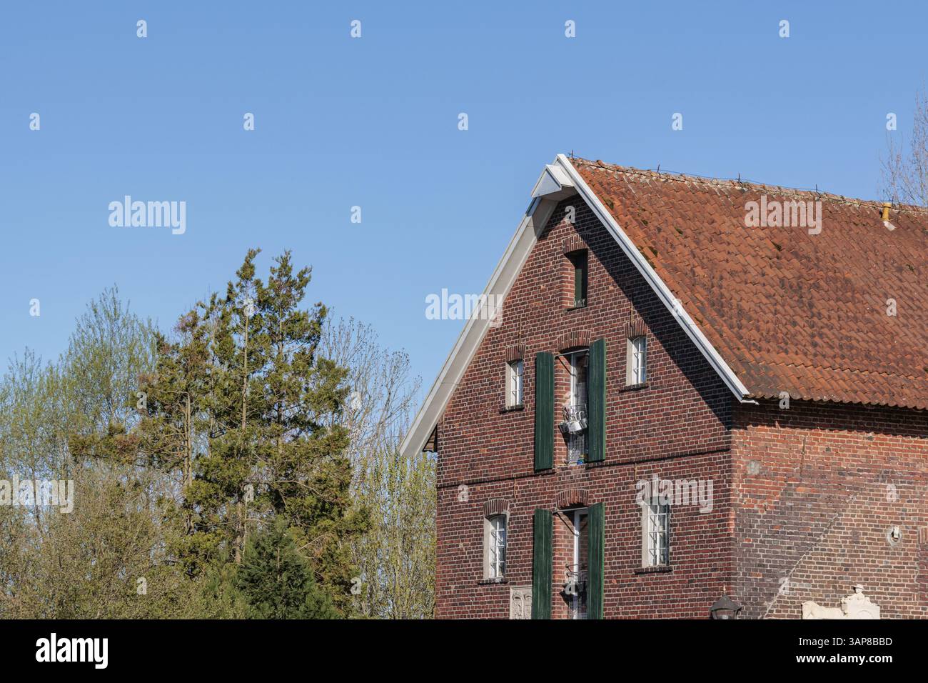 Altes Backsteingebäude mit rotem Dach in ländlicher Umgebung und klarem Himmel, Gescher, Münsterland, Deutschland, Europa Stockfoto