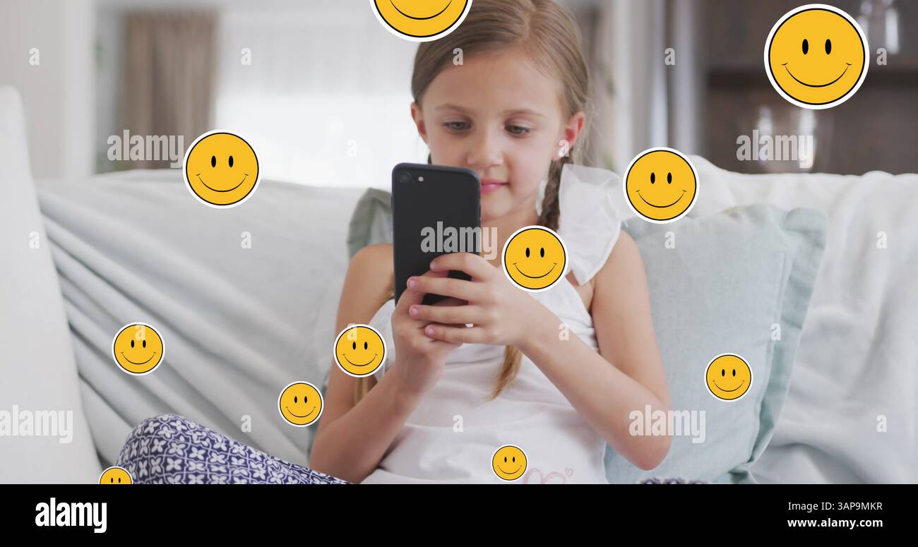 Bild von lächelnden Gesichtern über glückliches weißes Mädchen, das zu Hause ein Smartphone benutzt Stockfoto
