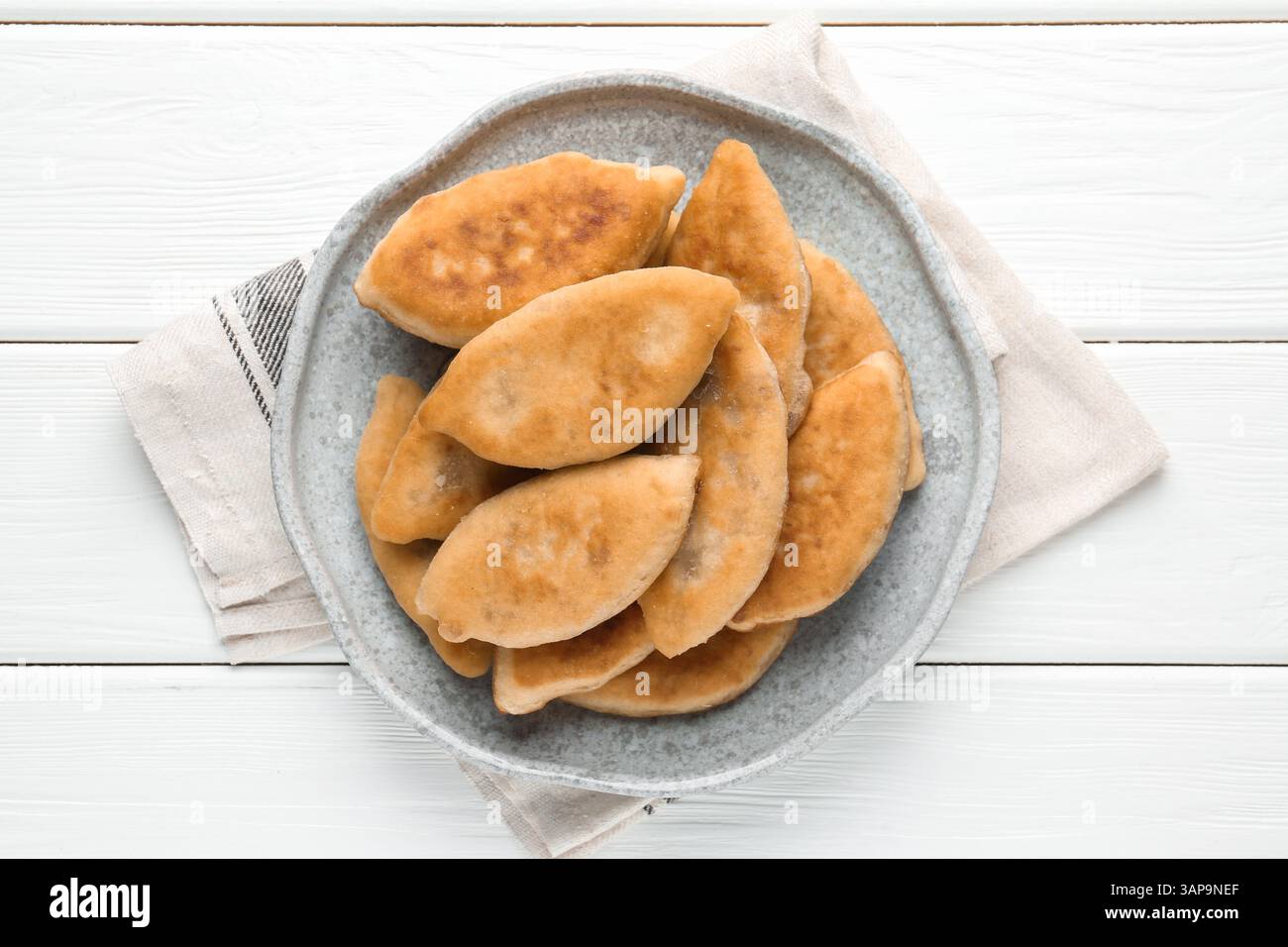 Köstliche gebratene Pyrizhky (gefüllte Kuchen) auf weißem Holztisch, Blick von oben Stockfoto Köstliche gebratene Pyrizhky (gefüllte Kuchen) auf weißem Holztisch, Blick von oben Stockfoto