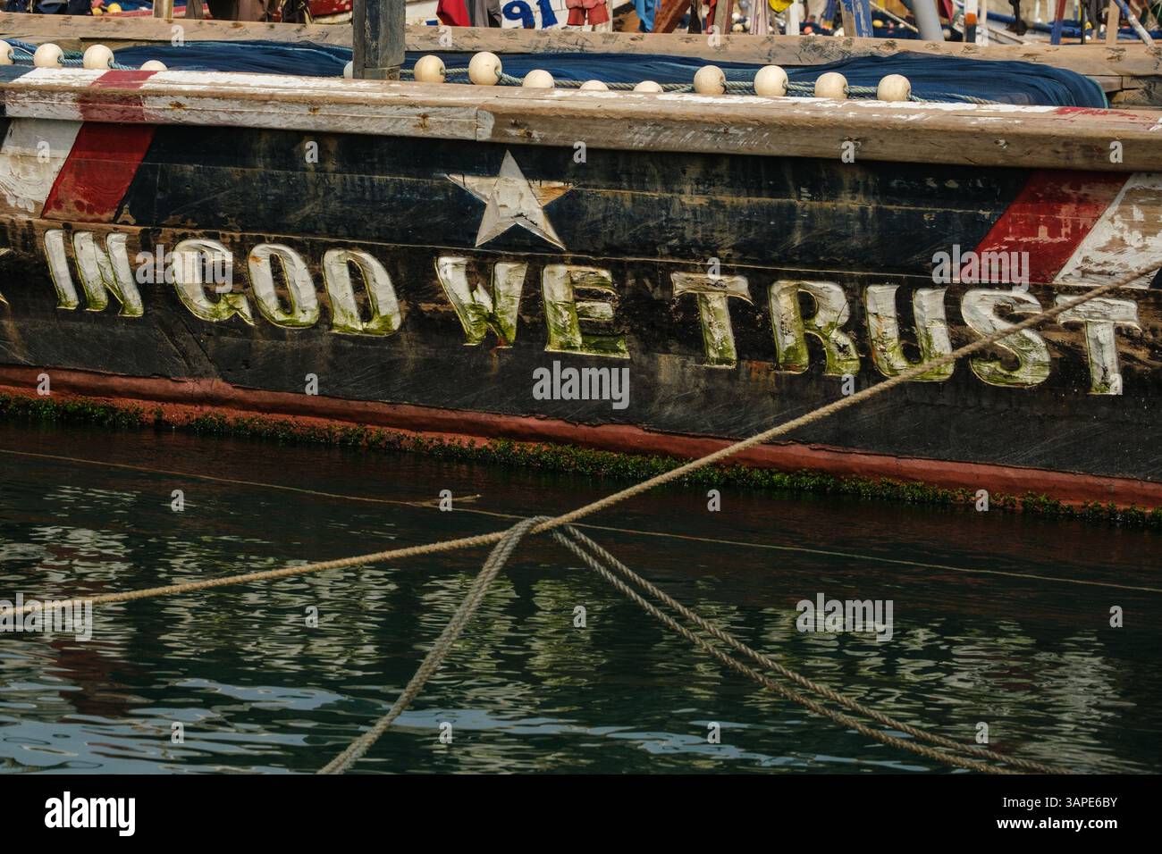 Accra, Ghana. Religiöser Slogan auf dem Fischerboot in Jamestown Fishing Harbor: In God We Trust. Stockfoto