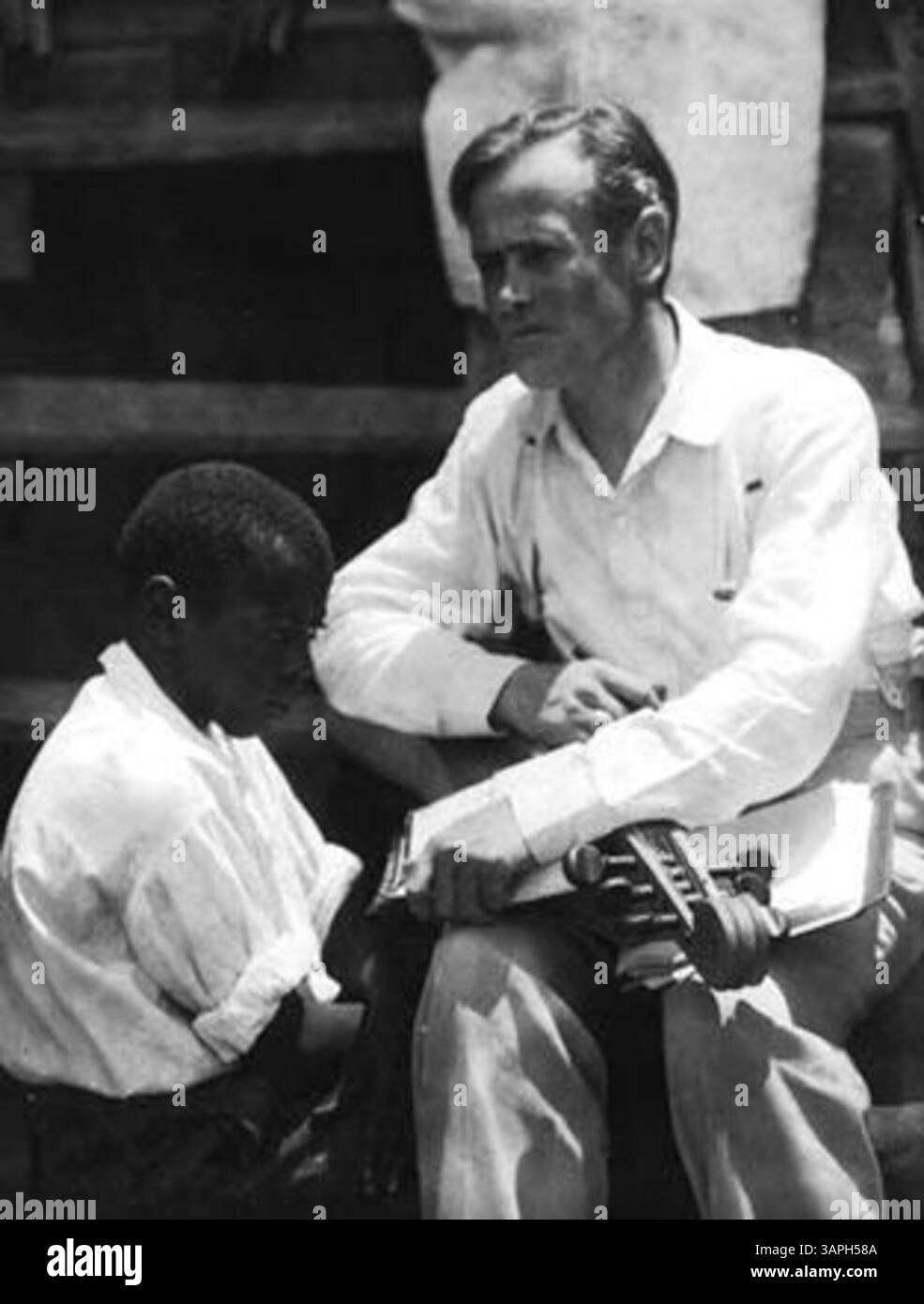 John Jacob Niles posiert mit einem afroamerikanischen Jungen, der in Berea, Kentucky, ein Appalachian Hackbrett spielt. Das Bild zeigt die Traditionen der Volksmusik in den Appalachen. Stockfoto
