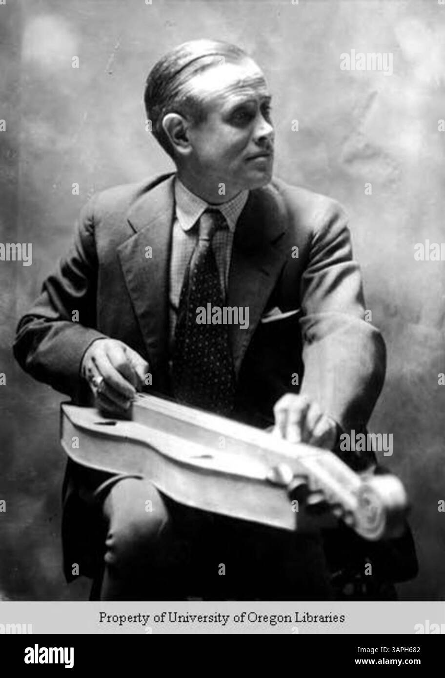 Foto von John Jacob Niles, einem prominenten amerikanischen Volksmusiker, der das Appalachen-Hackbrett spielt. Das Bild fängt Niles in einer Performance-Umgebung ein und zeigt das traditionelle Instrument. Stockfoto