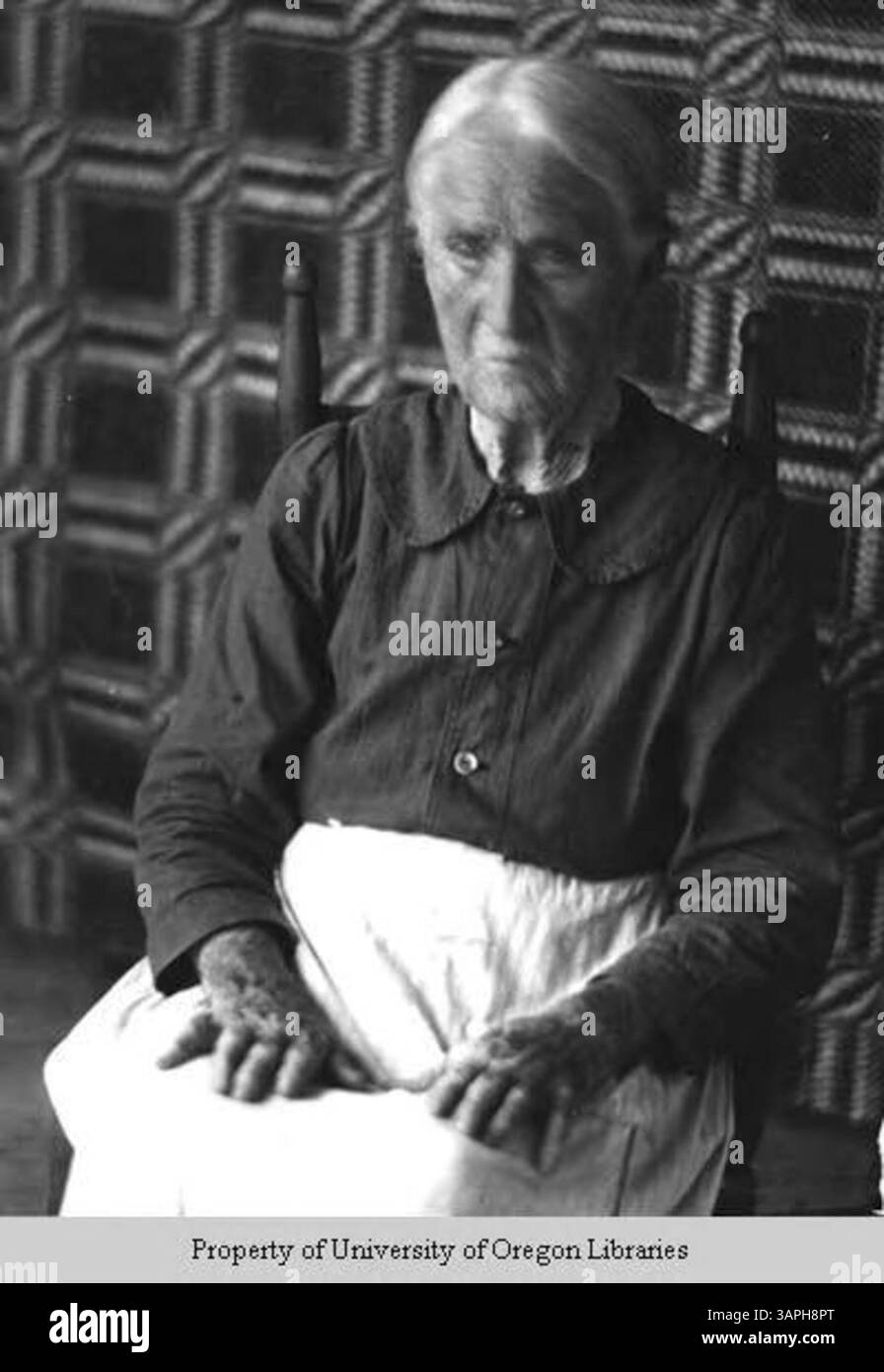 Dieses Foto zeigt Sarah Connelly, eine Spinnerin und Weberin, die vor einem gewebten Hänge steht. Das Bild zeigt die traditionelle Handwerkskunst in der Textilproduktion, wie sie in der Doris Ulmann Kollektion dokumentiert ist. Stockfoto