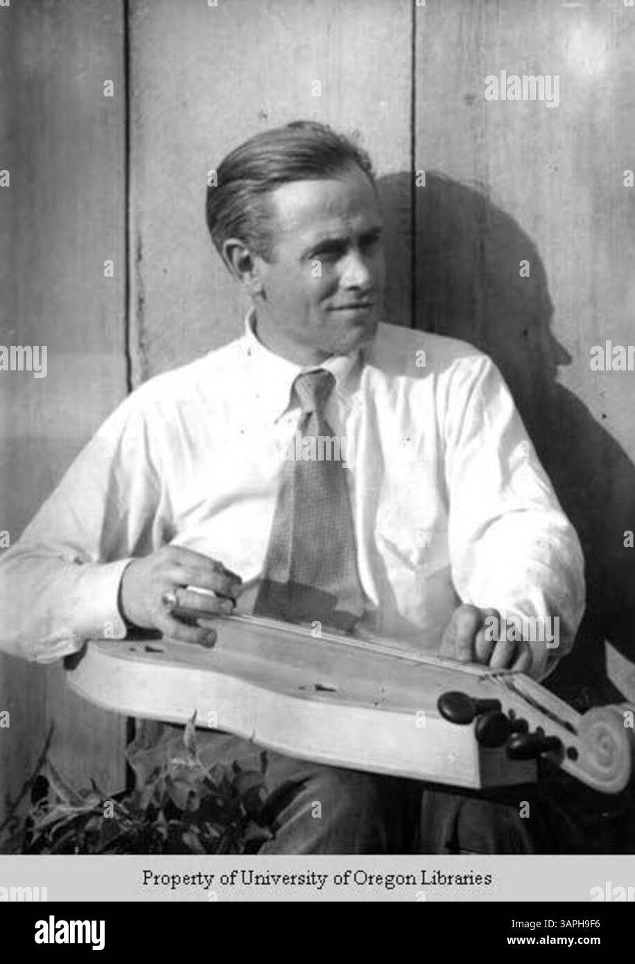 Dieses Foto zeigt John Jacob Niles, einen bekannten amerikanischen Folk-Sänger, mit seinem Appalachen-Hackbrett, einem traditionellen Instrument, das mit der Musik und Kultur der Appalachen assoziiert ist. Stockfoto