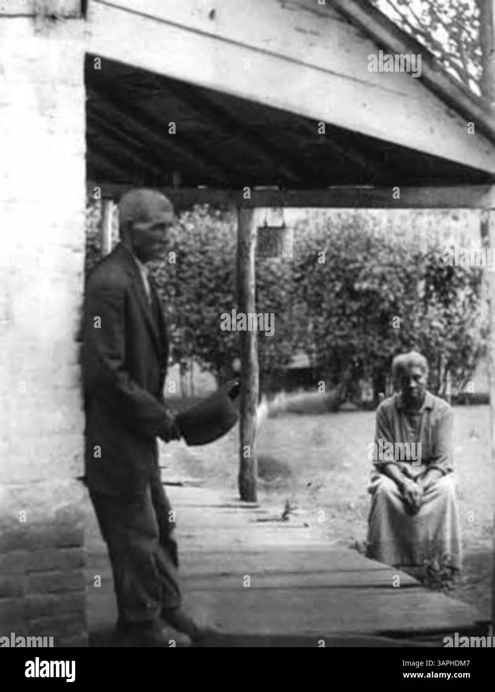 Dieses Foto zeigt eine afroamerikanische Frau und einen Mann, die auf einer Veranda in Berea sitzen. Es bietet einen Einblick in das tägliche Leben und bietet historische Einblicke in das afroamerikanische Leben im ländlichen Kentucky während des frühen 20. Jahrhunderts. Stockfoto