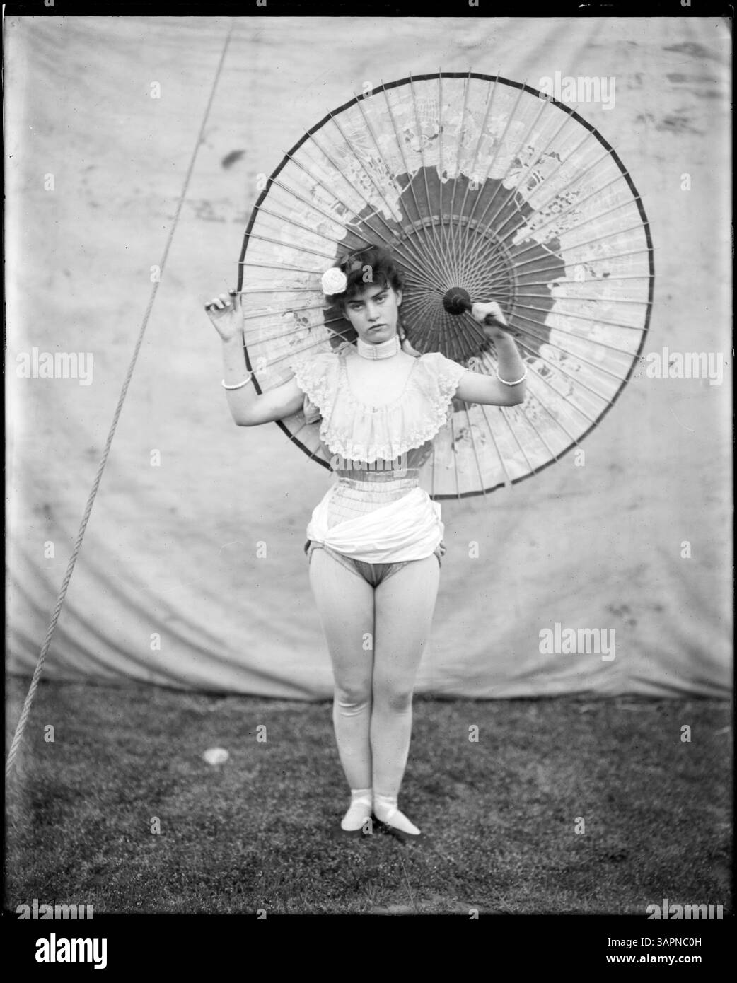 Dieses Foto mit dem Titel „Tight-Seil Walker, on Ground, Panamerikanischer Zirkus“ fängt einen Moment aus einer Zirkusvorführung ein und zeigt einen Tight-Seil Walker, der am Boden auftritt. Stockfoto