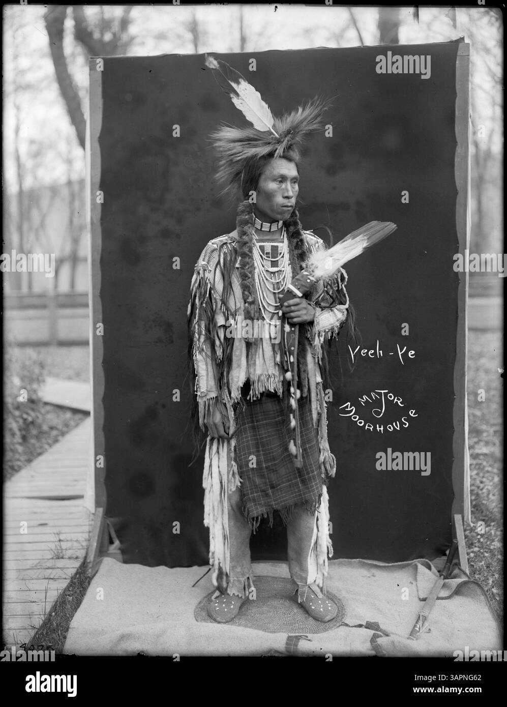 Dieses Foto von Lee Moorhouse zeigt Yee-YE, einen Umatilla-Indianer, in voller Insignien, in dem verschiedene Geräte und eine Pfeife im Hof von Moorhouse gehalten werden, was die Kultur der Umatilla-Stammesangehörigen widerspiegelt. Stockfoto