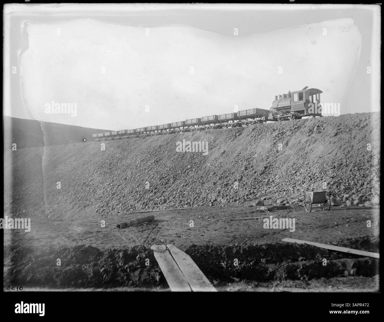Foto von Lee Moorhouse, das einen Zug aus 14 Müllwagen und einen Motor zeigt, der am Bau des Coe Dam in der Nähe von Stanfield, Oregon, arbeitet. Dieses Bild zeigt den industriellen Fortschritt im frühen 20. Jahrhundert. Stockfoto