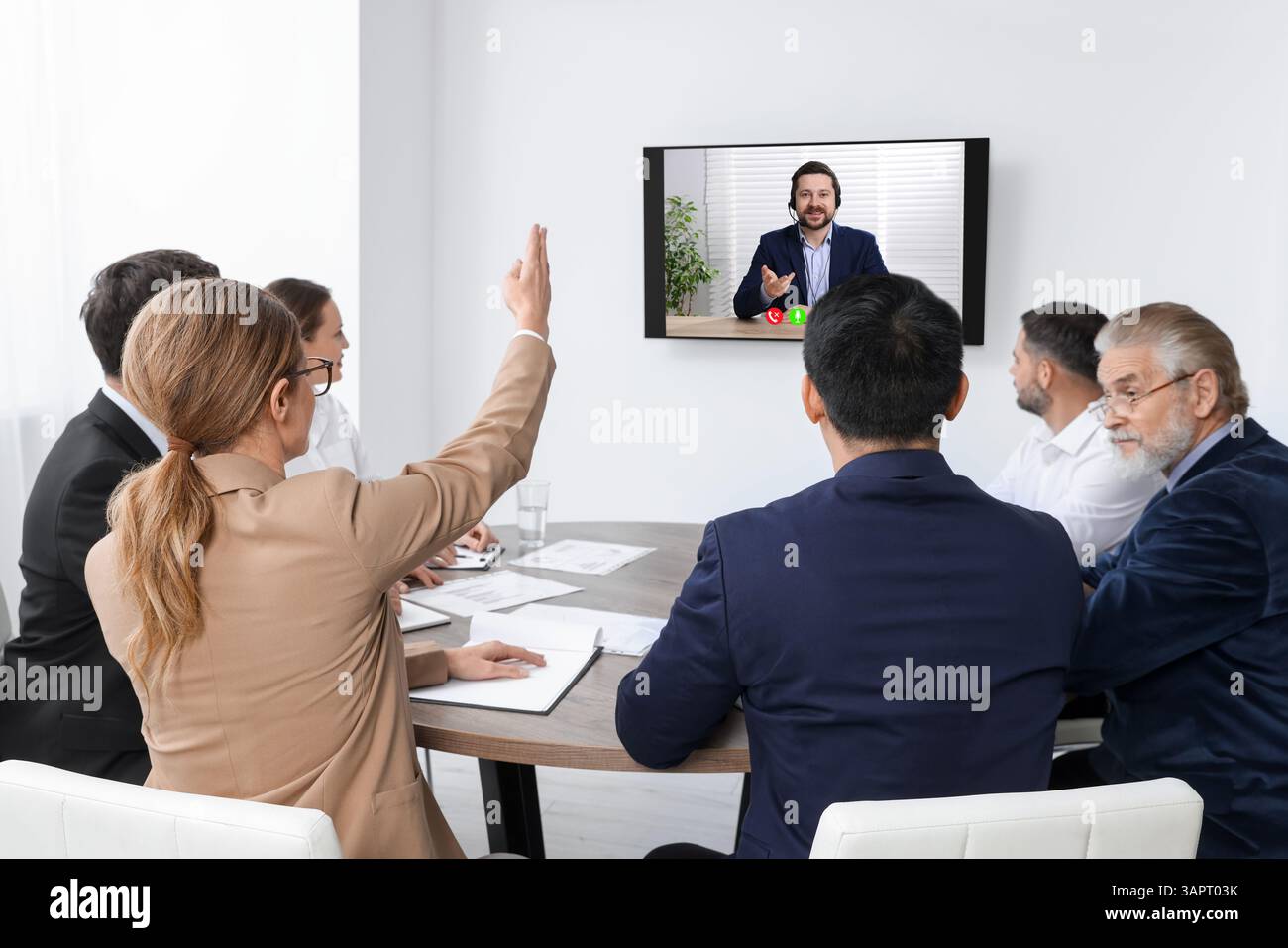 Redner, der über Online-Videochat an der Vorlesung teilnimmt. Publikum im Konferenzraum mit Fernseher Stockfoto