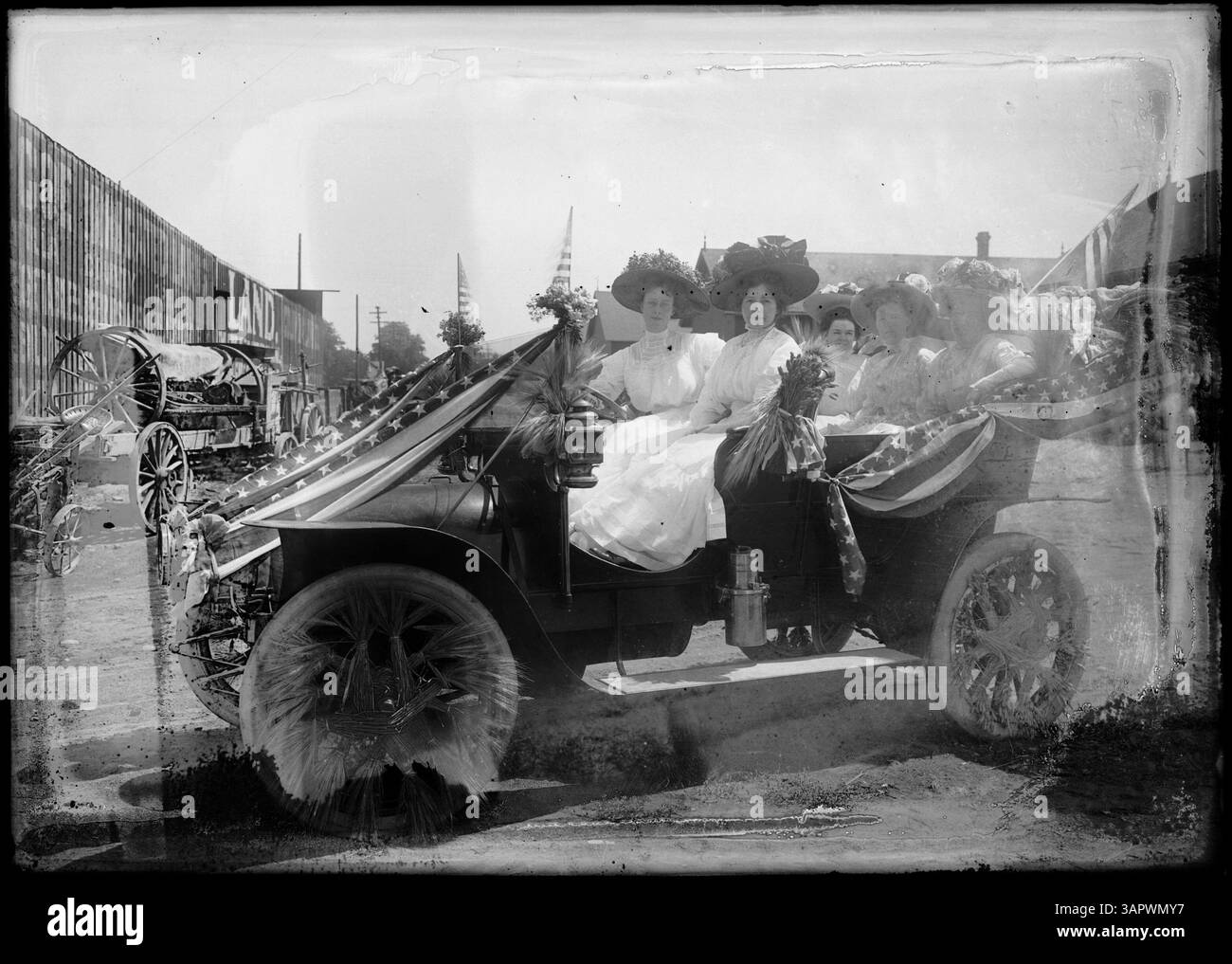 Foto eines frühen Modellautos, dekoriert für eine Parade, mit fünf Frauen innen, die eine Parade aus dem frühen 20. Jahrhundert in Pendleton aufnehmen. Stockfoto