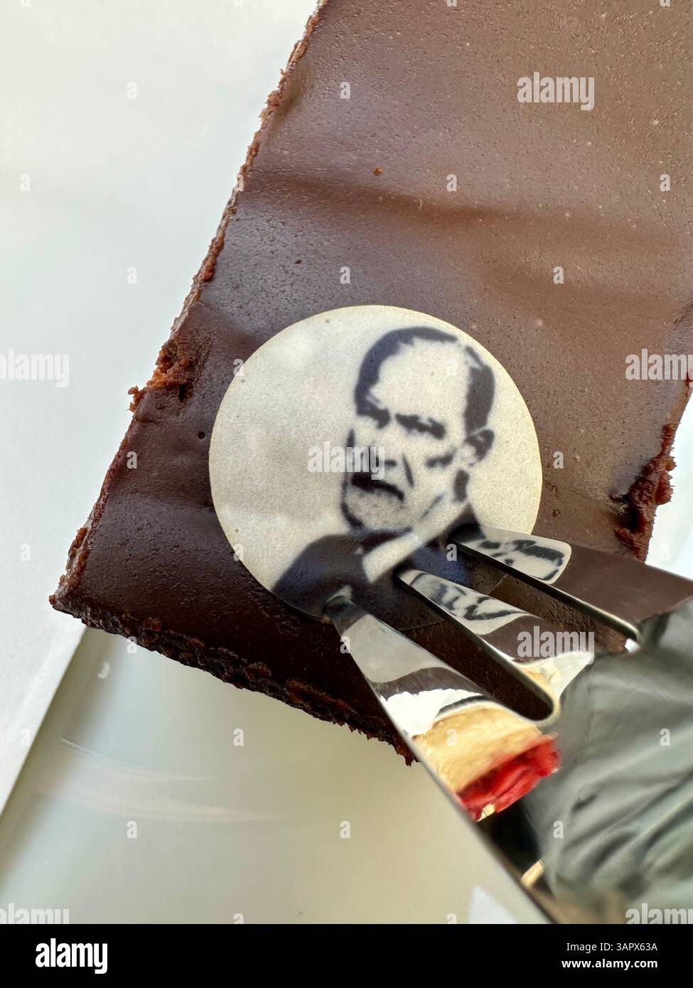 Essen einer sachertorte mit einem Bild von Sigmund Freud im Freud-Museum in Wien - Smartphone-aufgenommenes Stockfoto