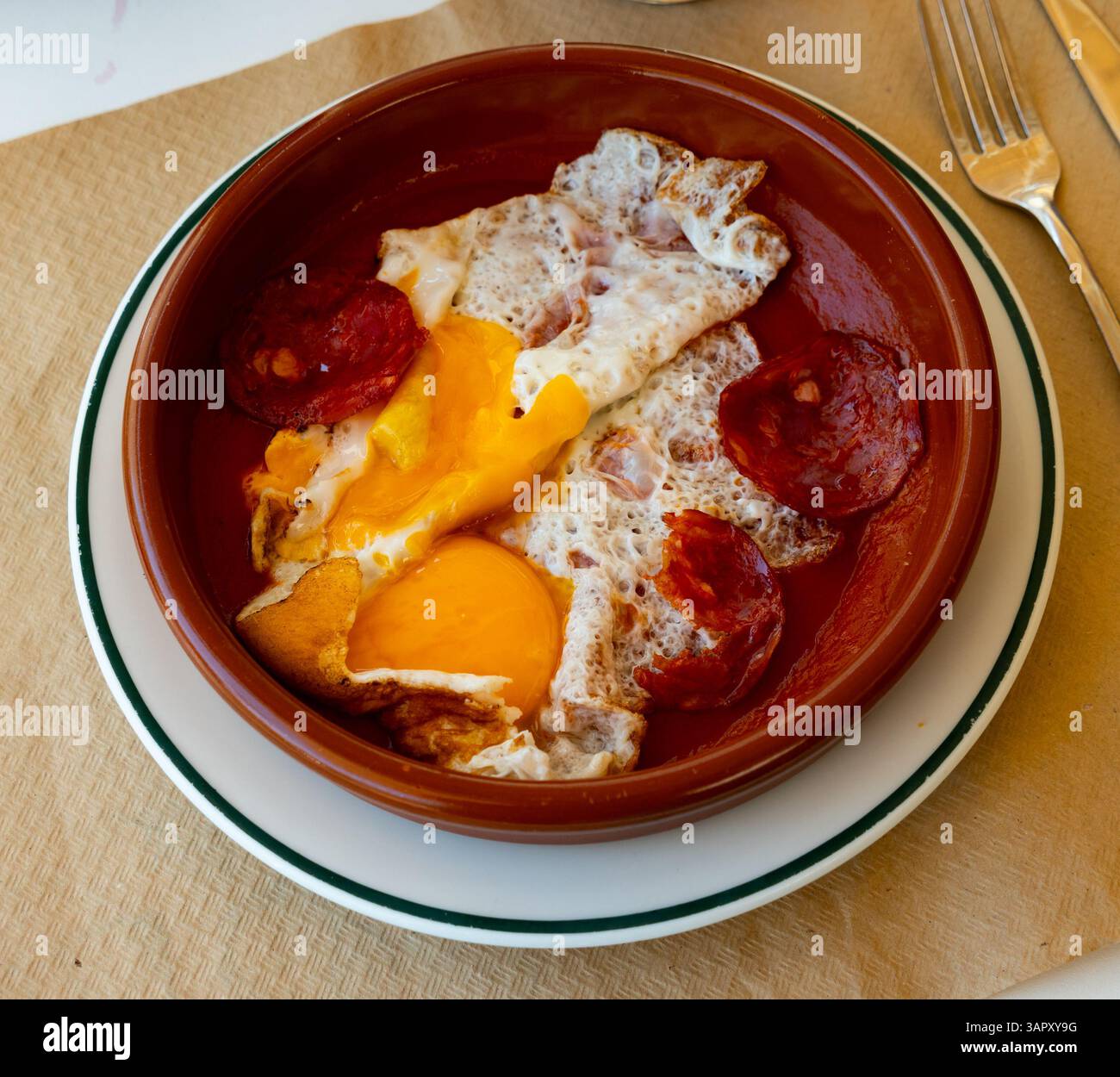 Spiegeleier mit Chorizo und Tomatenpaste in der Pfanne Stockfoto