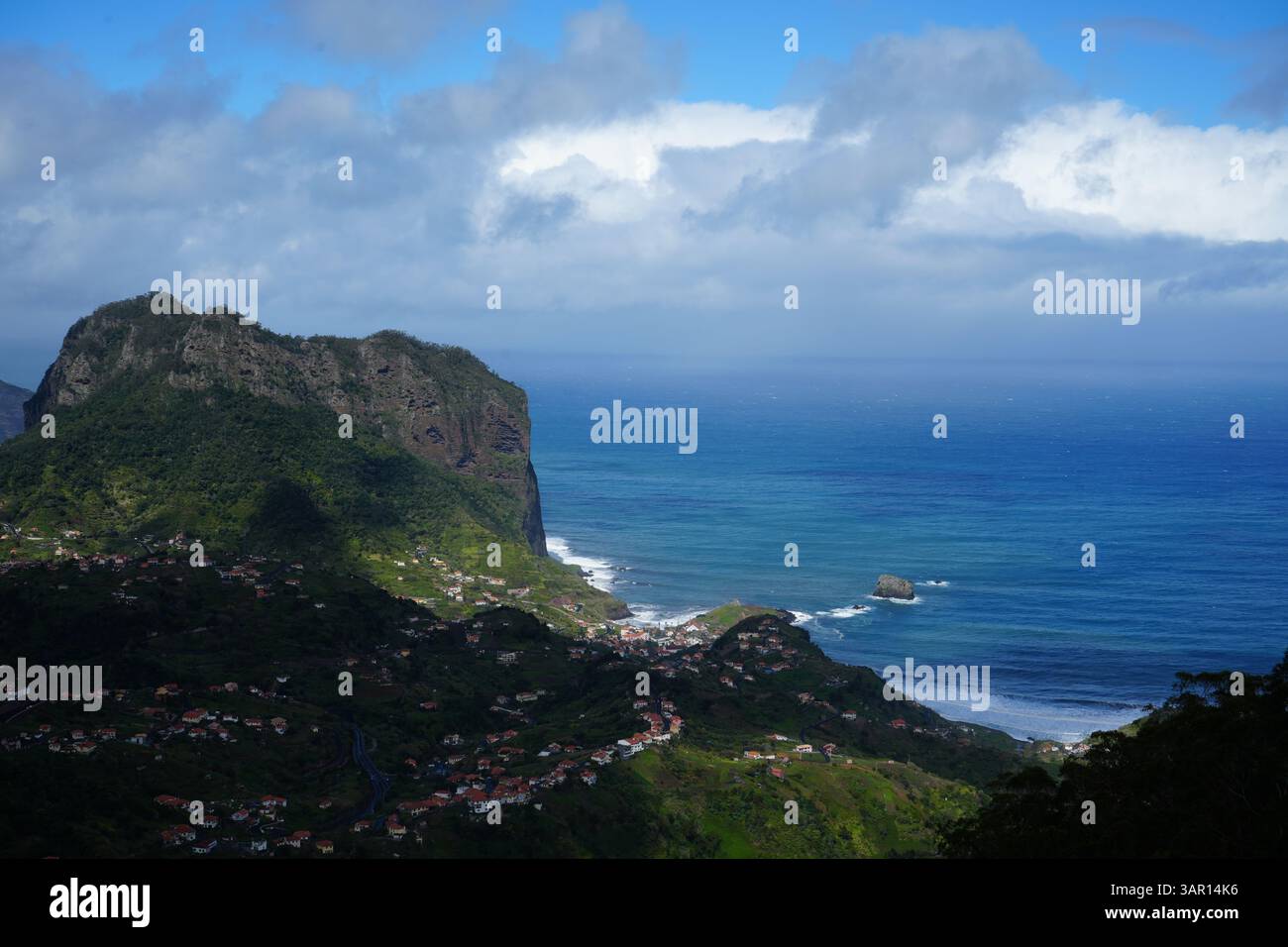 Atemberaubender Blick aus der Vogelperspektive auf die Küstenklippen und die üppig grünen Dörfer der nördlichen Region Madeira, Portugal, mit dem Atlantischen Ozean, der sich im Inneren erstreckt Stockfoto