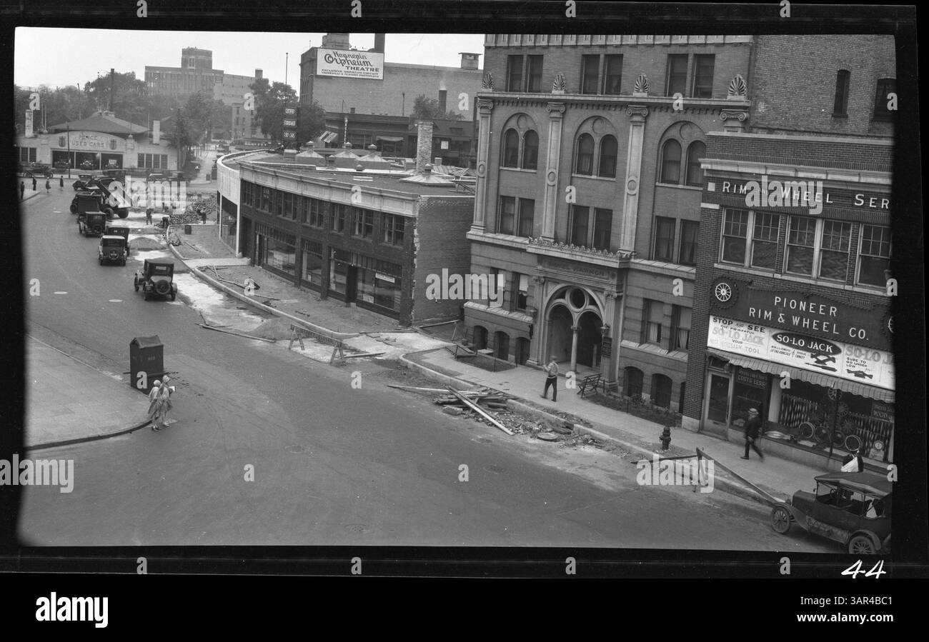 Dieses Bild zeigt den Blick nach Norden entlang der 10th Street und des Harmon Place während einer Zeit der Stadtentwicklung. Pence Gebrauchtwagen und das Orpheum Theater sind im Hintergrund zu sehen und stellen wichtige Sehenswürdigkeiten in der Gegend dar. Stockfoto