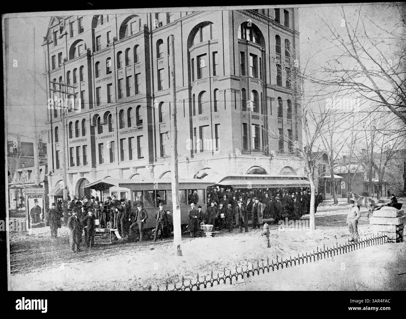 Dieses historische Bild zeigt eine Gruppe von Männern, die auf Trolley-Wagen vor dem Tribune Building posiert. Links ist ein Poster mit der Werbung für eine Show namens „Florence“ zu sehen. Die Motor Line wurde später zur Minneapolis Street Railroad Company. Stockfoto