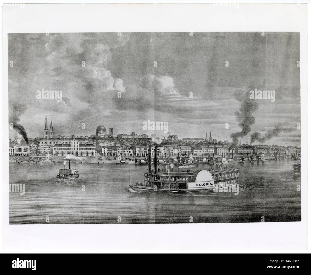 Dieses Schwarzweiß-Foto zeigt einen Blick auf St. Louis von der Illinois-Seite des Mississippi River, wobei das Dampfschiff St. Louis auf dem Fluss sichtbar ist. Mehrere weitere Dampfschiffe liegen am Missouri Deich an. Stockfoto