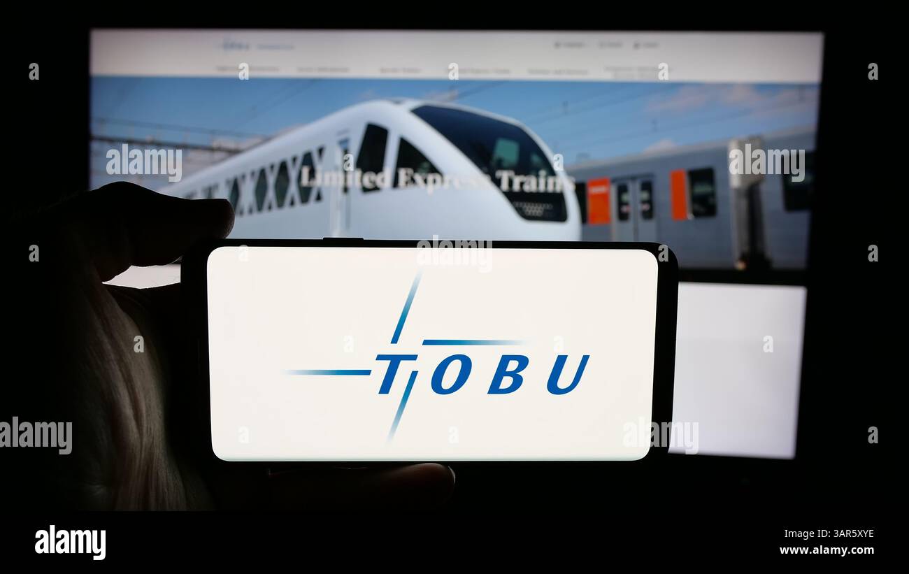 Auf dieser Abbildung befindet sich ein Mobiltelefon mit dem Logo des japanischen Unternehmens Tobu Railway Company Ltd. Auf dem Bildschirm vor der Webseite. Stockfoto