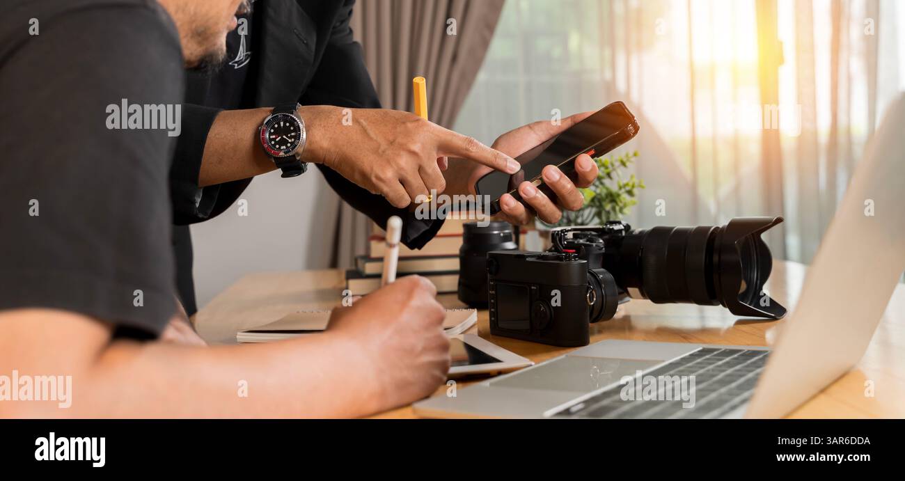 Ein Mann, der zu Hause Bilder vor der Kamera überprüft. Fotograf, der seine Arbeit überprüft. Männer, die in der Nachrichtenredaktion arbeiten. Der Fotograf und sein Model machen Pho Stockfoto