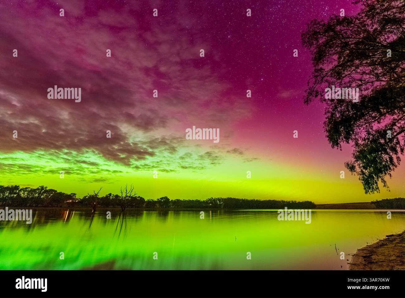 Farbenfrohe Aurora Australis spiegelt sich im stillen Wasser des Cairn Curran Reservoir am Joyces Creek in Central Victoria, Australien. Stockfoto