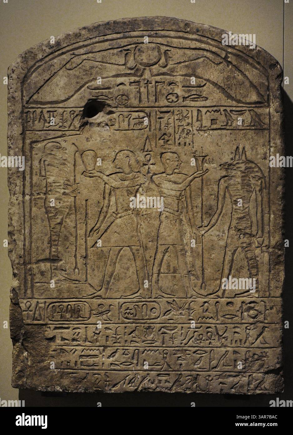 Stele von König Seankhiptah. Auf der linken Seite ist der König vor dem Gott Ptah und dargestellt. Auf der rechten Seite präsentiert Nebsumenu (der Stelenspender) Anubis ein Opfer. Im folgenden Text wird ein Verfahren zur Umwidmung von Flächen erwähnt, bei dem landwirtschaftliche Nutzflächen in Bezirke umgewandelt werden. Zweite Zwischenperiode. Dynastien 13.-14. 1785-1633 V. CHR. Kalkstein. Nationales Archäologisches Museum. Madrid. Spanien. Stockfoto