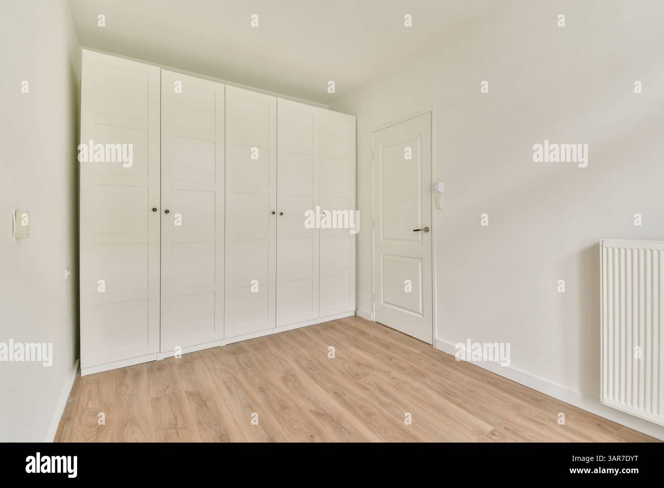 Eine helle, moderne Inneneinrichtung mit klaren Linien, hellen Wänden und Naturholzböden, die die minimalistische Ästhetik unterstreichen. Stockfoto